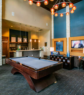 a pool table sits in the middle of a room with a bar