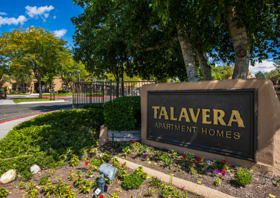 a sign for talavera apartment homes in front of a park with trees