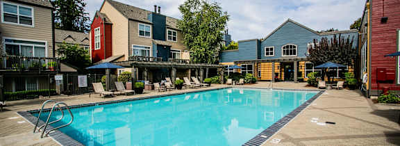a swimming pool at a resort with chairs and umbrellas