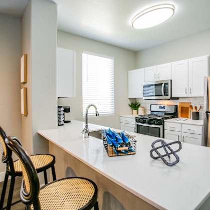 a kitchen with white cabinetry and stainless steel appliances