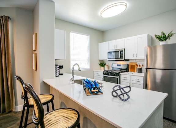 a kitchen with white cabinetry and stainless steel appliances