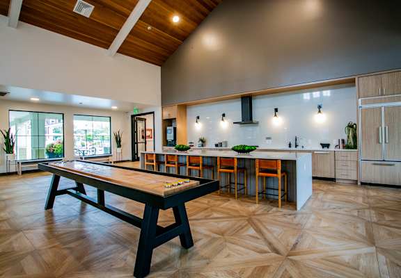 a game room with a pool table and a kitchen