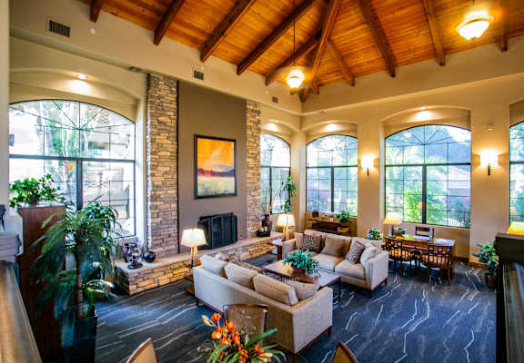 a living room with couches and a fireplace and large windows