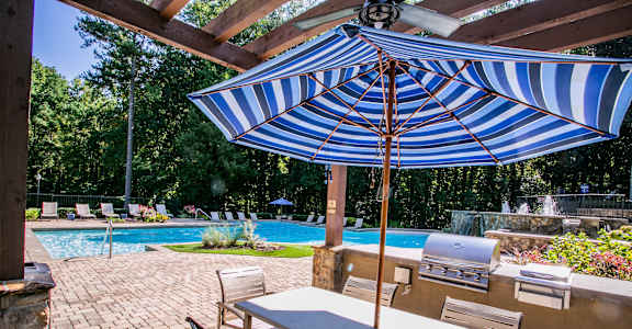 A blue and white striped umbrella is over a table.