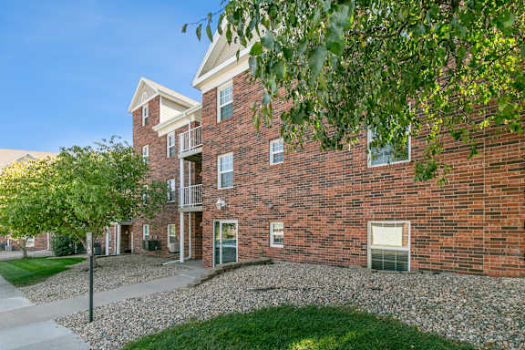A red brick building with a tree in front.