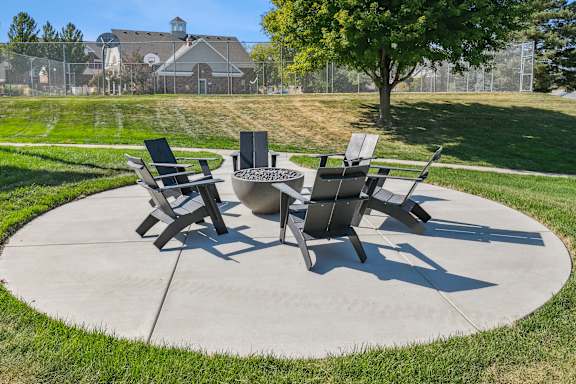 A concrete patio with four chairs and a table.