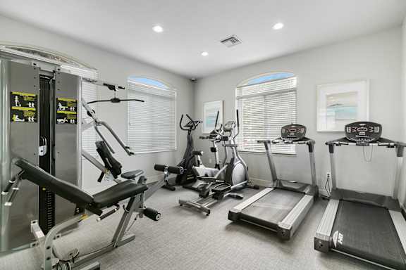 A well-equipped home gym with treadmills, weights, and exercise machines.