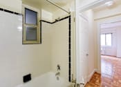 Thumbnail 12 of 20 - bathroom with tub, window, tile detail and view of bedroom at sherry hall apartments in washington dc