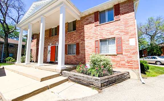 A house with a white porch and a red door.