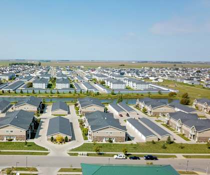 A large, well-organized residential complex with a parking lot in the foreground.