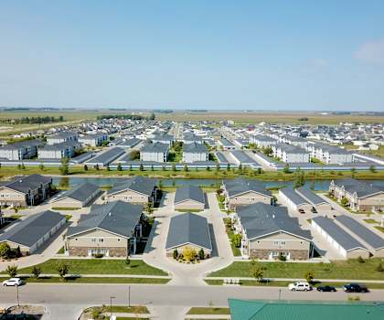A large, well-organized residential complex with a parking lot in the foreground.