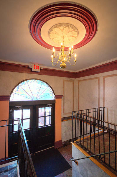 Entrance to property with golden chandelier above steps