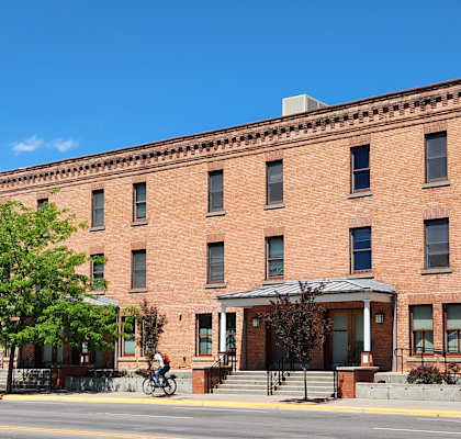 A red brick building with a balcony on the second floor.