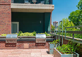 a patio with plants and a building in the background