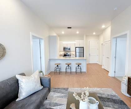 a living room with a couch and a kitchen in the background