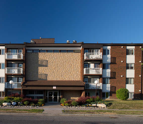 A large brick building with a brown facade and balconies.