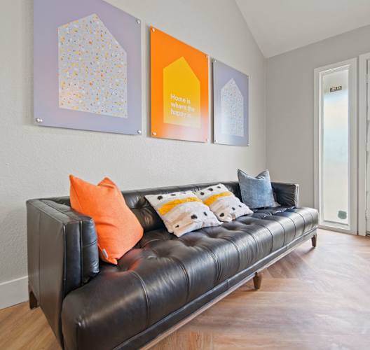 a living room with a leather couch and a door to a balcony