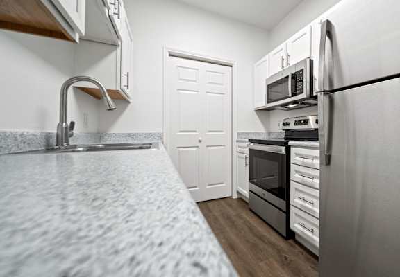 a kitchen with granite countertops and stainless steel appliances