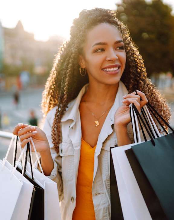 A woman with shopping bags in a city setting.