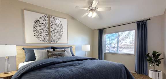 A bedroom with a large bed and a ceiling fan.