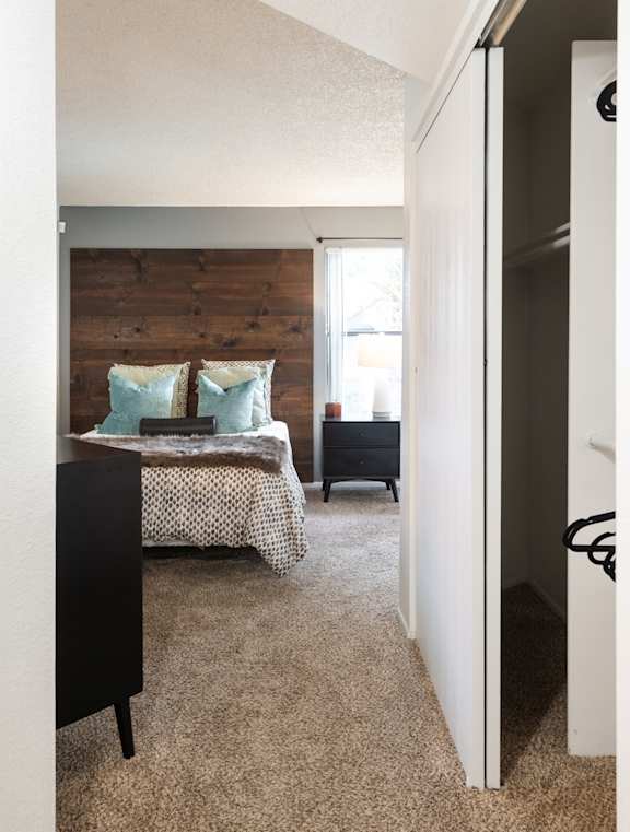 A bedroom with a bed and a wooden headboard.
