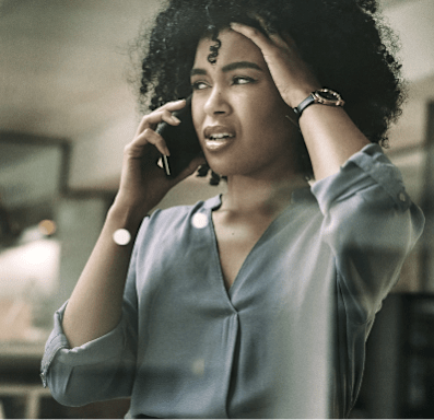 A woman with curly hair is talking on a phone.