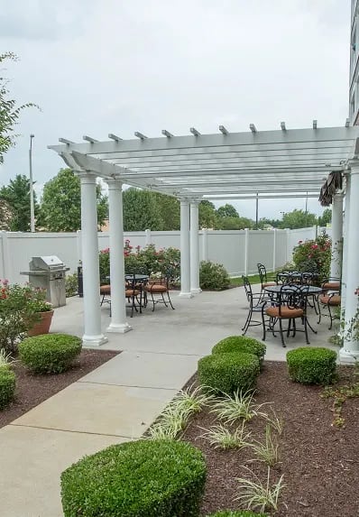 a patio with a pergola and tables and chairs