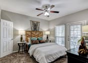 Thumbnail 9 of 54 - A bedroom with a large bed and a ceiling fan.