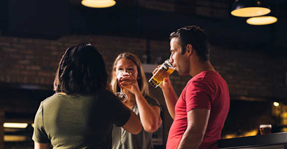 a man and a woman drinking beer in a bar