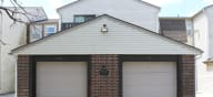 a garage with two garage doors in front of a house at Canyon Creek Apartments, Kansas City, 64132