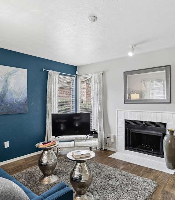 A living room with a grey couch and a fireplace.