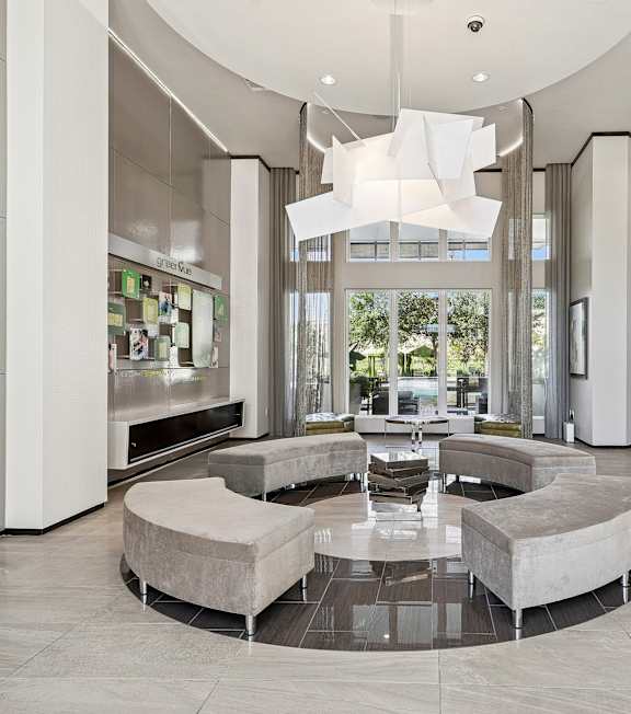 A modern living room with a large circular table in the center.