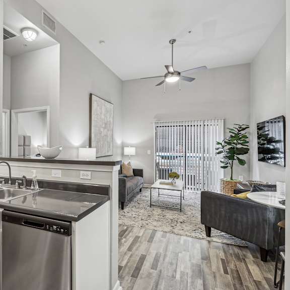 A modern kitchen with a stainless steel dishwasher and white cabinets.