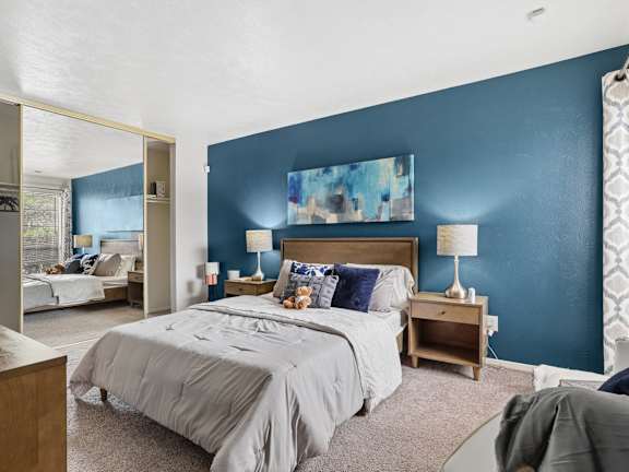 A bedroom with a large bed and a painting on the wall.
