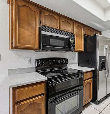 A kitchen with black appliances and wooden cabinets.