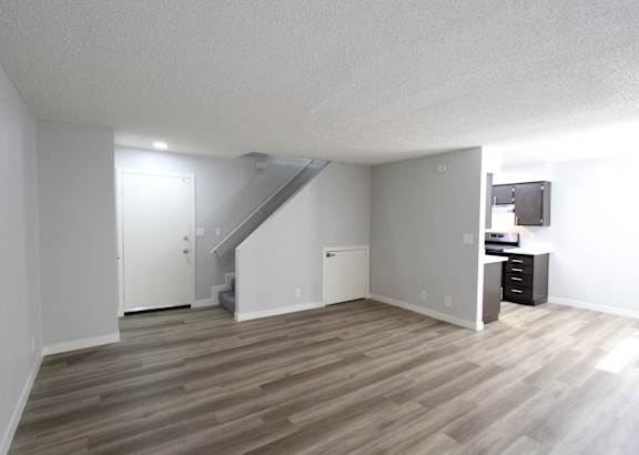a kitchen with black cabinets and stainless steel appliances and a white counter top