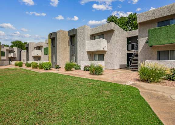 a building with concrete walls and a green lawn and grass