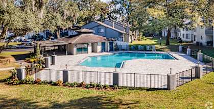 a swimming pool with a fence around it in front of a house