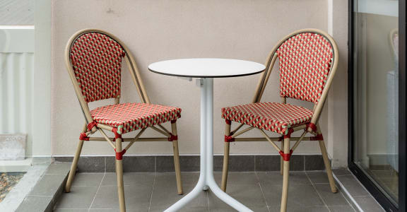 a patio with two chairs and a table on a balcony