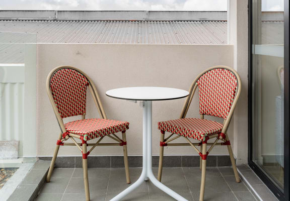 a patio with two chairs and a table on a balcony