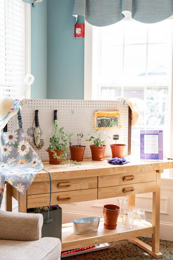 A wooden desk with a pegboard and potted plants on it.
