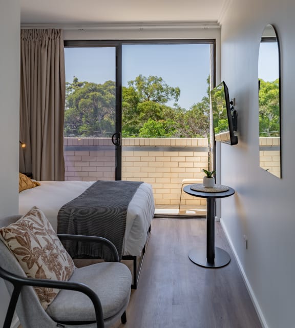 a hotel room with a bed and a chair and a window