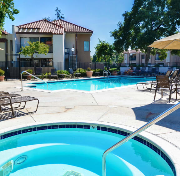 our apartments have a swimming pool with chairs and umbrellas