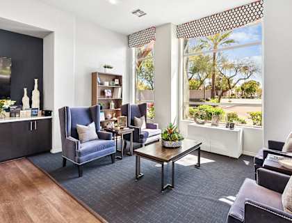 A living room with a dark blue sofa and a wooden coffee table.