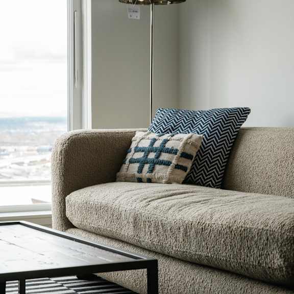 a couch with a pillow in front of a window
