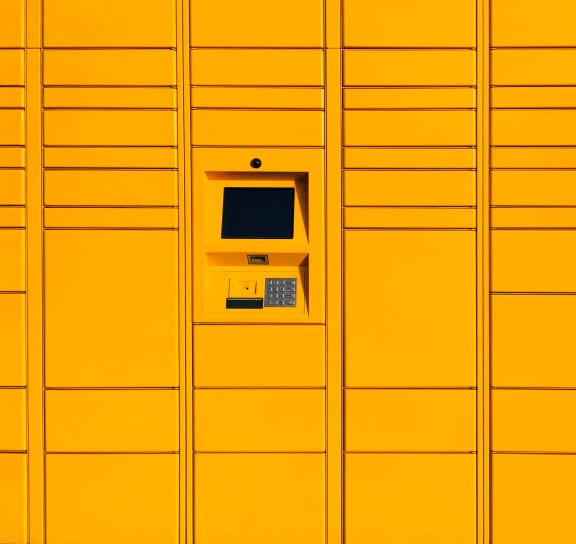 a yellow wall of lockers with a machine on it