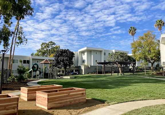 A white building with a green lawn in front of it.