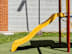 A yellow slide in a playground.