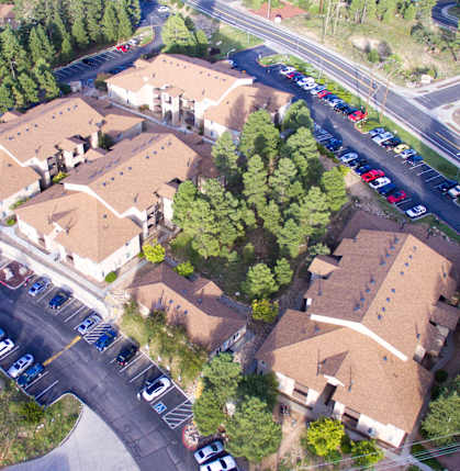 A road with cars and apartment buildings.