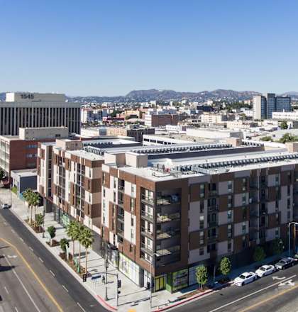 A city street with apartment buildings and cars at Wilshire Valencia Apartment, California